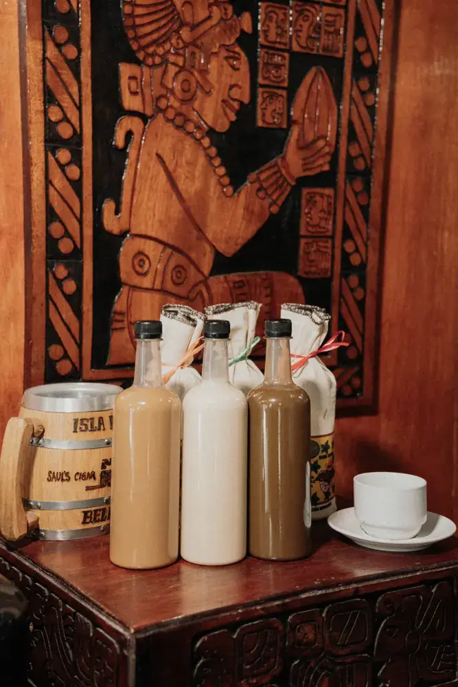 Bottles of rum cream beside a cup of coffee