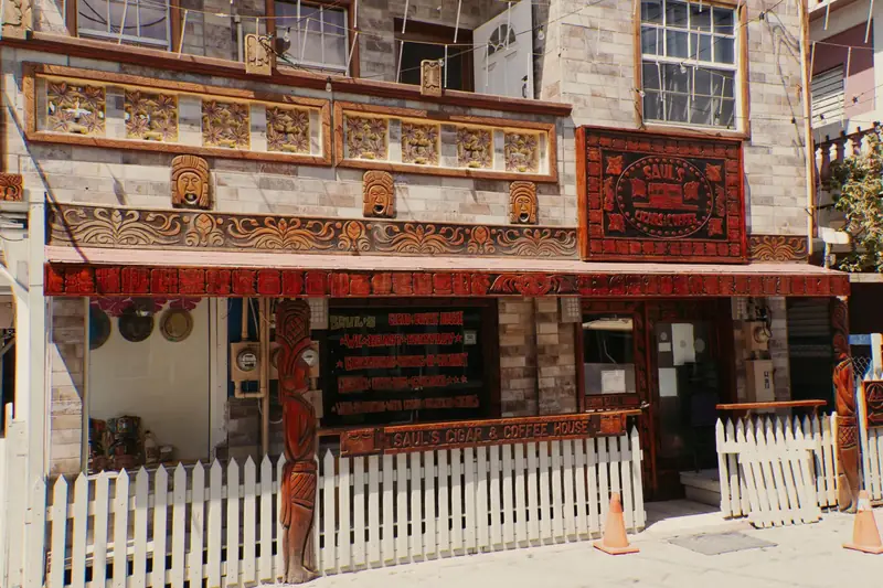 The carved wooden front of Saul's Cigar & Coffee House on Pescador Drive